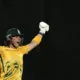 Dewald Brevis raises his arms after reaching a hundred